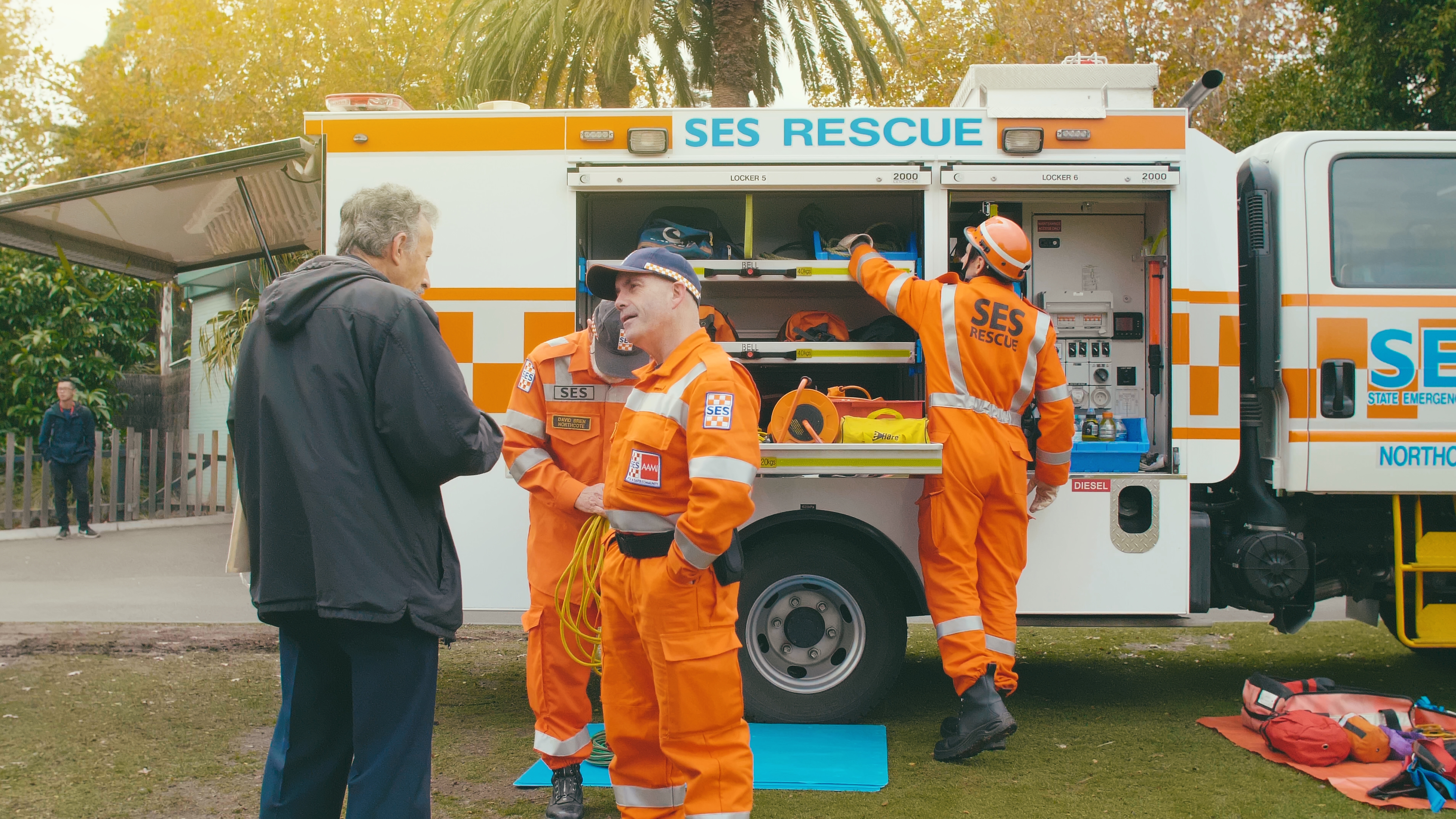 VICSES volunteers chatting with a community member in front of a VICSES vehicle